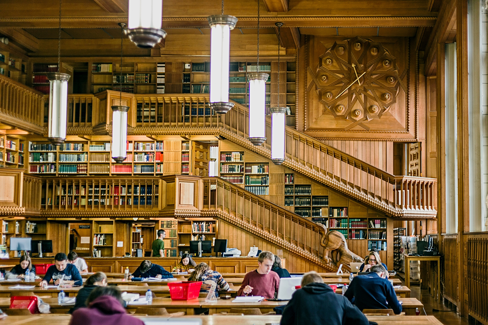 shutterstock 518447815   Students  inside the library of the uni Leuven, Belgium, from the years 1425.